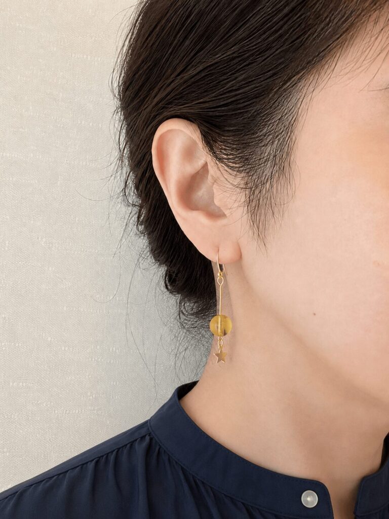 シトリンのロングピアスをつけた女性